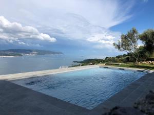 einen Pool mit Blick auf das Wasser in der Unterkunft Villa Bellosguardo Apartments in La Spezia