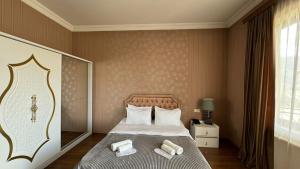 a bedroom with a bed with two towels on it at Hotel Rich in Tbilisi City