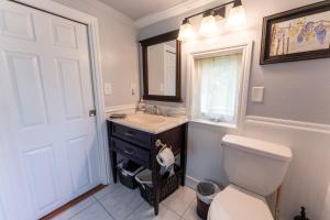 a bathroom with a toilet and a sink and a mirror at Little Red Caboose in Oakhurst