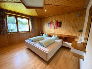 a bedroom with a bed in a room with wooden walls at Ferienhaus Schaiter - Ganzes Haus mit Garten und gratis Parkplatz in Innsbruck