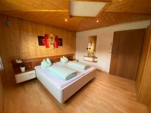 a bedroom with a large white bed with wooden walls at Ferienhaus Schaiter - Ganzes Haus mit Garten und gratis Parkplatz in Innsbruck
