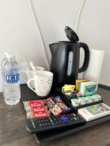 a table with a coffee pot and a remote control at Dana guest suite in Horley