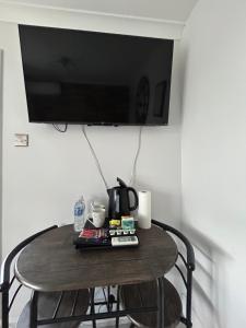 a small table with a tv on a wall at Dana guest suite in Horley