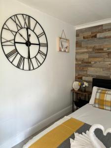 una camera da letto con un grande orologio sul muro di Dana guest suite a Horley