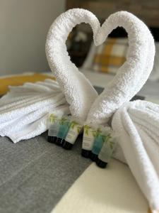 um par de toalhas e um coração numa cama em Dana guest suite em Horley