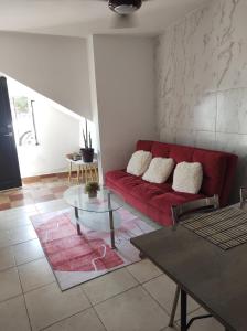 ein Wohnzimmer mit einem roten Sofa und einem Tisch in der Unterkunft Hospedaje con Jacqueline in Boca del Río