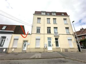 Un edificio con una freccia rossa sul lato. di Le Cosy Dunkerquois Centre Ville a Dunkerque