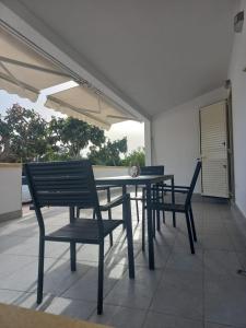シラクーサにあるSeaside Serenity Villa IGMAのダイニングテーブルと椅子付きのパティオ