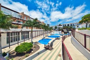 an apartment balcony with two pools and palm trees at Ocean view perfect sunset apartment, 4 rooms 137m2, WiFi & BBQ in San Miguel de Abona
