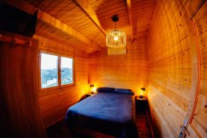 a bedroom with a bed in a wooden room at Casa La Loma in Granada