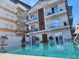 a hotel with a swimming pool in front of a building at Hotel Villa ATA in Durrës