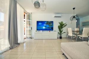 a living room with a flat screen tv on a wall at Ocean view perfect sunset apartment, 4 rooms 137m2, WiFi & BBQ in San Miguel de Abona