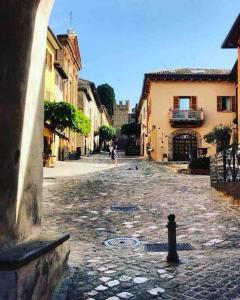 a person walking down a cobblestone street at Appartamento bella vista dal castello al mare in Gradara