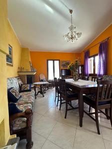 a dining room with a table and chairs and a couch at Maria s Apartment in Tertenìa