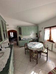 a kitchen with green cabinets and a table and chairs at Maria s Apartment in Tertenìa