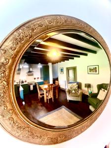 a mirror reflecting a living room with a table and chairs at Stay Northside - Luxury Corporate & Leisure Stays Cottage, County Durham in Newton Aycliffe