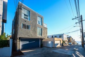 a large brick building with a garage on a street at Beachside Luxury 4BR Arcade Fun Ocean Views in Manhattan Beach