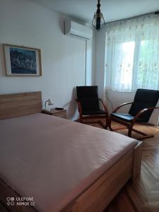 een slaapkamer met 2 stoelen en een bed bij Krisztina apartman in Balatonfüred