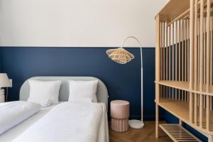 - une chambre avec 2 lits et un mur bleu dans l'établissement UP'arts, à Wrocław