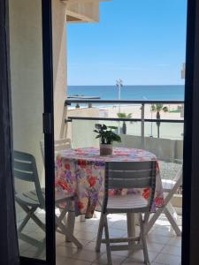 a table with a potted plant on a balcony with the beach at Studio cosy vue mer Canet Plage 3étoiles in Canet-en-Roussillon