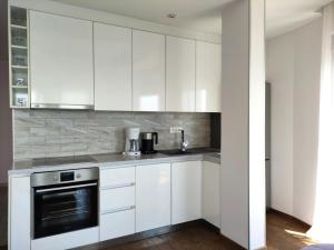 a white kitchen with white cabinets and appliances at Altezza Luxury Apartment 11 in Budva