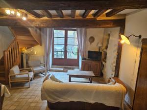 a bedroom with a bed and a living room at Le petit Conté - Maison calme en centre ville in Sées