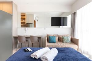 a bedroom with a blue bed and a couch at Makia Beach Experience Muro Alto por Brevelar in Porto De Galinhas +129 photos