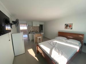 una piccola camera da letto con un letto e una cucina di My Flat 0 a Praia