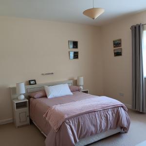 um quarto com uma cama grande e uma janela em Home from home in East Galway em Ballycrossaun