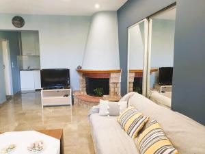 a living room with a couch and a fireplace at VILLA ARHONTIKO in Asprovalta