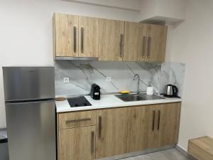 a kitchen with wooden cabinets and a stainless steel refrigerator at F&M House Semi Basement in Sarti +8 photos
