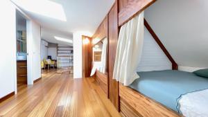 a bedroom with a bed and a wooden floor at The Cliffs - MarCastelos in Viveiro