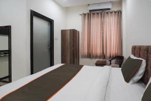 ein Hotelzimmer mit einem Bett und einem Stuhl in der Unterkunft Hotel City Pride in Raipur