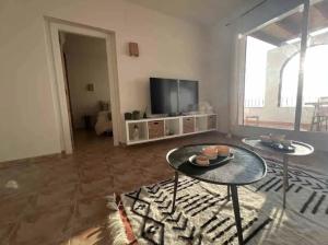 a living room with two tables and a television at Spectacular Panorama in Benitachell