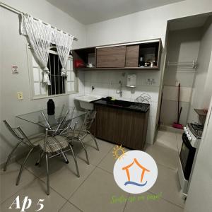 a kitchen with a table and chairs and a counter at Ape privativo no Brisamar - 10min Praia de Itaparica - Sentir-se em Casa! in Vila Velha