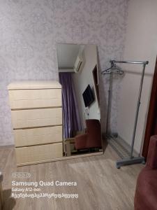 a room with a dresser and a mirror at Hotel Zaira in Tbilisi City