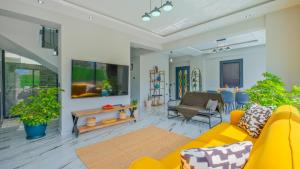 a living room with a yellow couch and a table at vİLLA SÖĞÜT in Fethiye