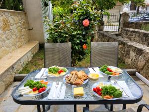 a table with plates of food on it at Anris & Dianas Dom - In a quiet part of the center in Kallithea Halkidikis