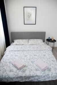 a bedroom with a bed with two towels on it at Nano Apartment in Prizren