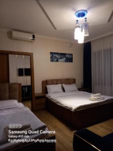 a bedroom with two beds and a chandelier at Hotel Zaira in Tbilisi City