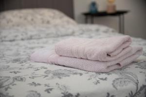 einen Stapel Handtücher auf dem Bett in der Unterkunft Nano Apartment in Prizren