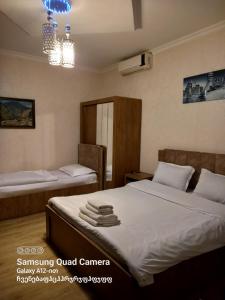 a bedroom with two beds and a chandelier at Hotel Zaira in Tbilisi City