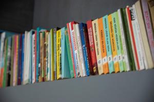 a row of books sitting on a shelf at Nano Apartment in Prizren
