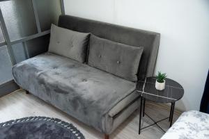a couch in a living room with a table at Nano Apartment in Prizren