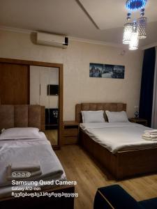 - une chambre avec 2 lits et un miroir dans l'établissement Hotel Zaira, à Tbilissi