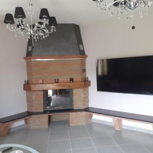 a living room with a fireplace and a television at casavacanze Baggioro in Colle di Compito