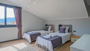 a bedroom with two beds and a large window at vİLLA SÖĞÜT in Fethiye +13 photos