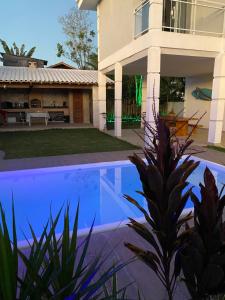 a house with a swimming pool in front of a house at Recanto Casa de Itaúna in Saquarema