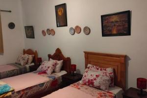 a room with two beds and clocks on the wall at appart J in Essaouira