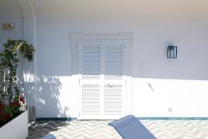 a blue chair sitting in front of a white door at o' mar - Amalfi Coast Suite in Praiano